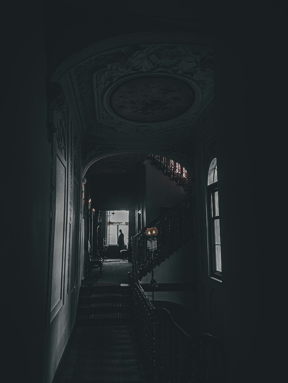 a dark hallway with a staircase leading to another room