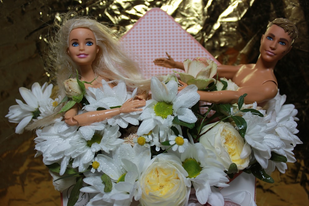 a barbie doll and a doll in a bouquet of flowers