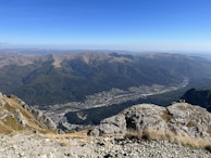 Travelers capturing the moment atop a hill with sweeping views of the valley below.