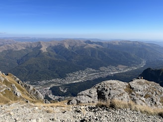 Travelers capturing the moment atop a hill with sweeping views of the valley below.