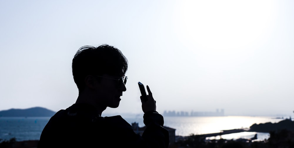 a silhouette of a man holding a cell phone