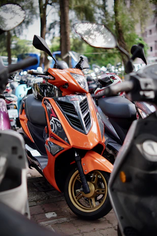 A close-up of a sleek scooter parked near Jagannath Temple with vibrant orange and blue hues in the background.