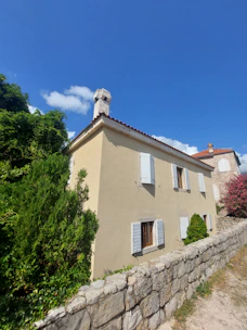 A renovated bright Mediterranean home featuring a blue sky and warm orange accents.