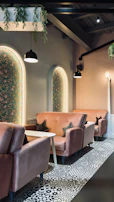 Warm, inviting corner of the studio with plush seating and soft pink nude decor.