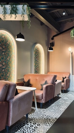 A boutique corner of the studio featuring plush black seating and warm ivory walls.