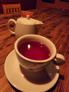 A steaming cup of tea placed on a wooden table.