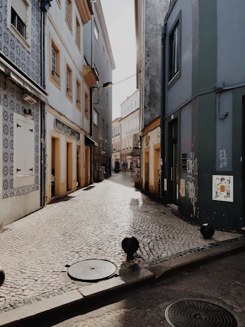 A quiet cobblestone street bathed in soft morning light, framed by minimalist architecture.