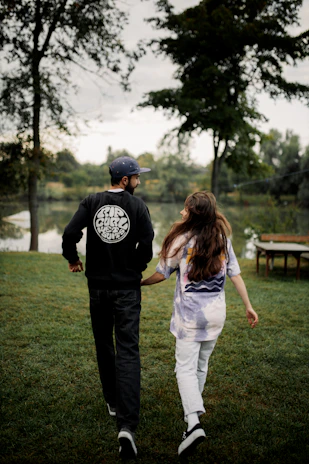 Couple walking hand in hand along a calm lake at dawn