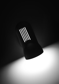 Close-up of a sleek, professional lighting fixture casting precise light beams in a dark room.