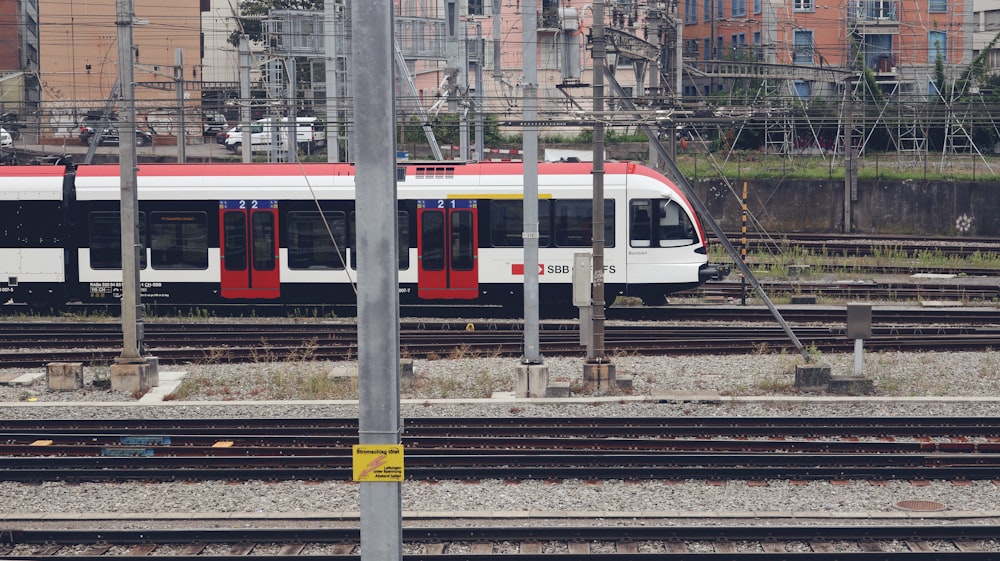 a red and white train traveling down train tracks