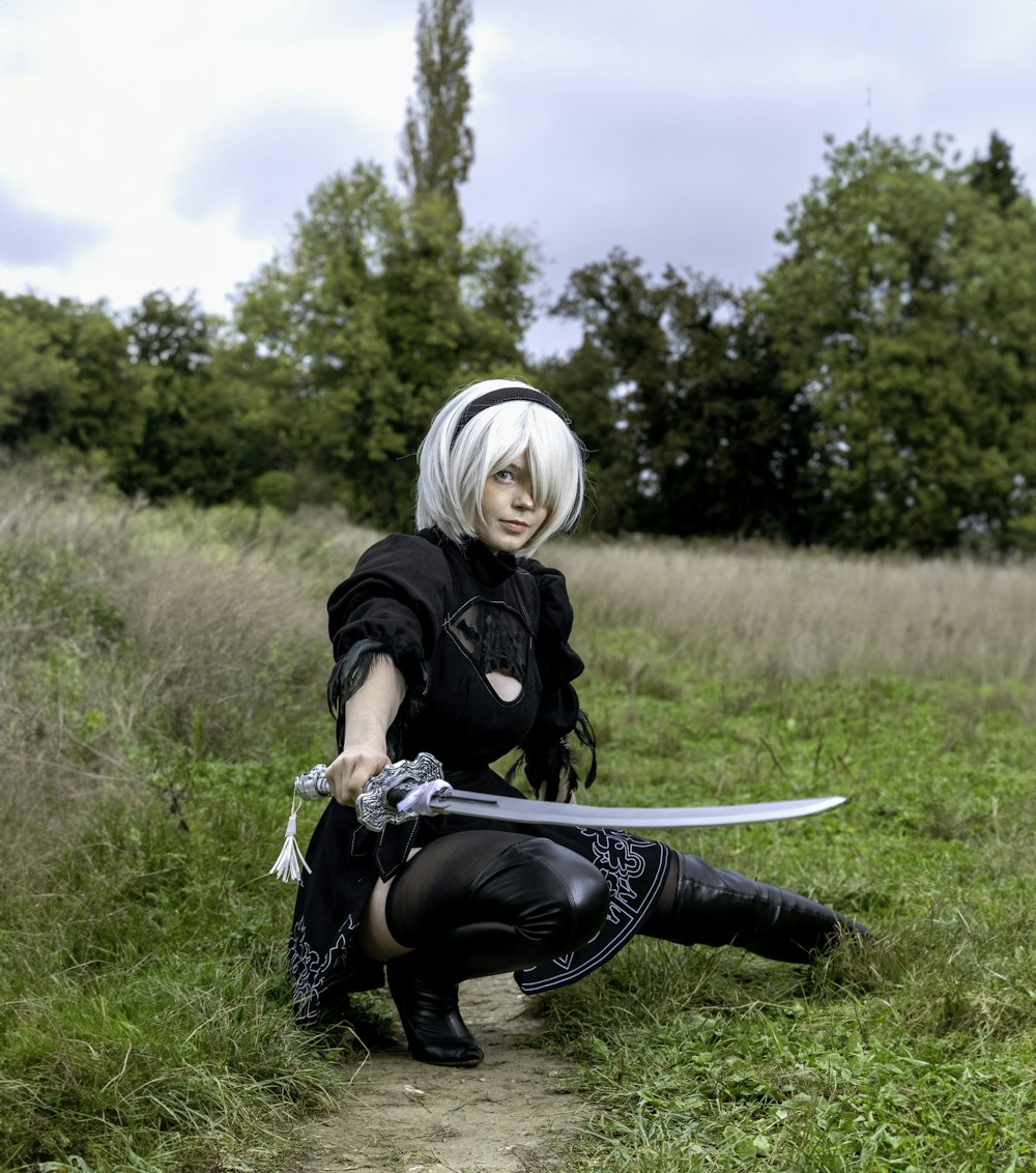 a woman in a black outfit holding a sword