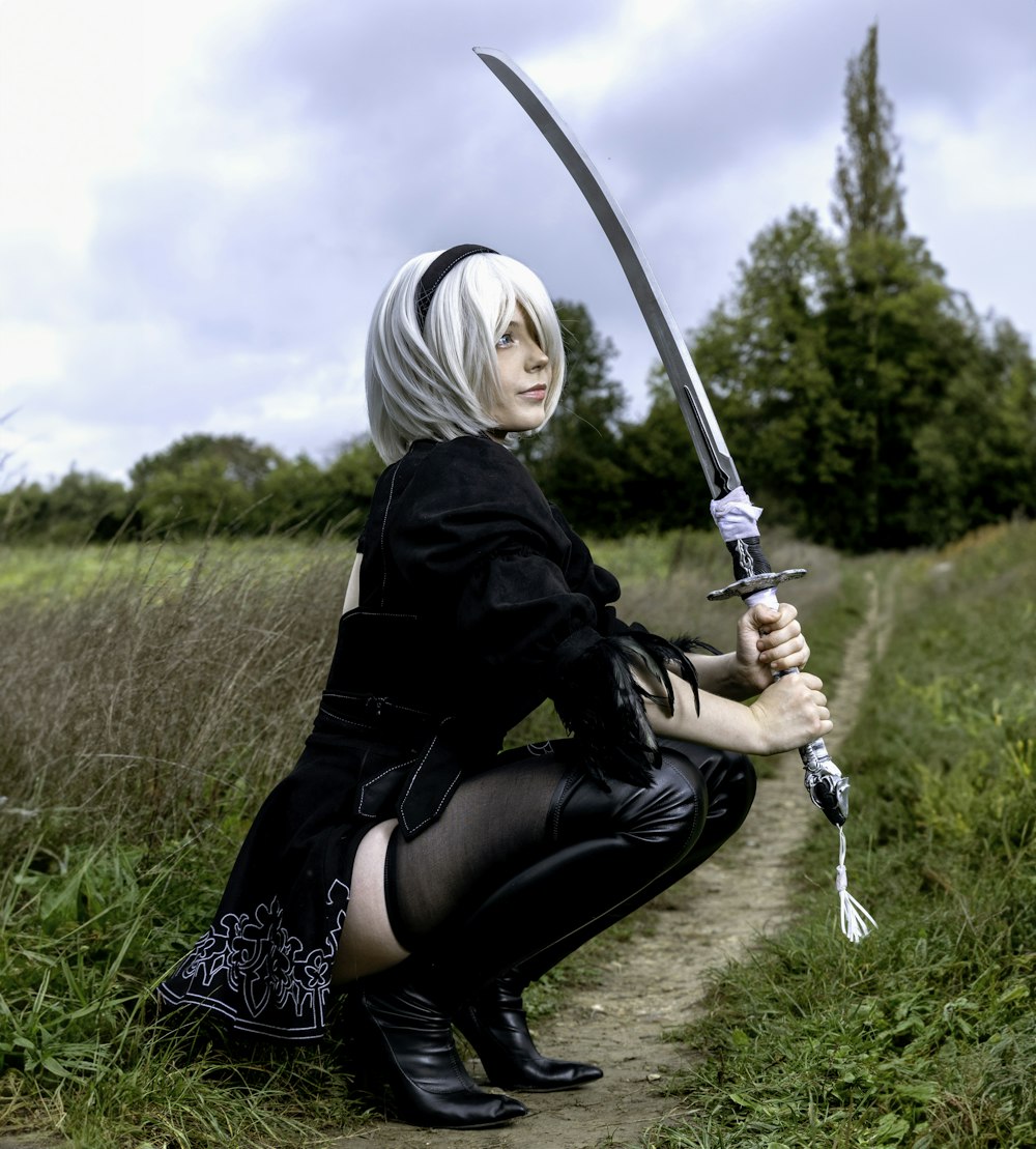 a woman kneeling down with a sword in her hand