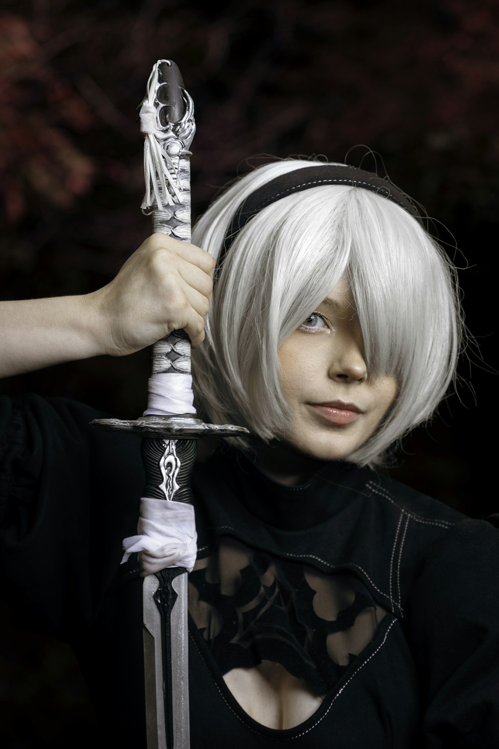 a woman with white hair holding a sword