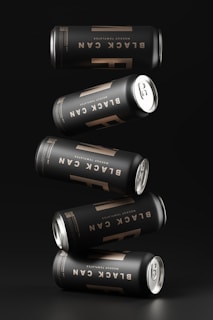 a group of four cans of beer on a black background
