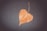 A serene image of a heart-shaped leaf resting on a wooden surface.