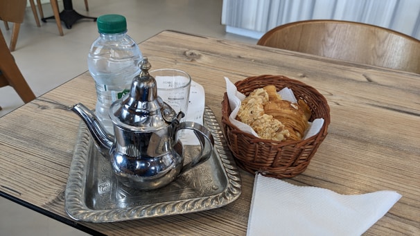 A rustic table with a selection of pastries and a steaming cup of tea.