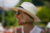 a woman wearing a white hat and sunglasses