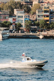 Marine security patrol boat cruising near a pier with crew members actively monitoring the surroundings.