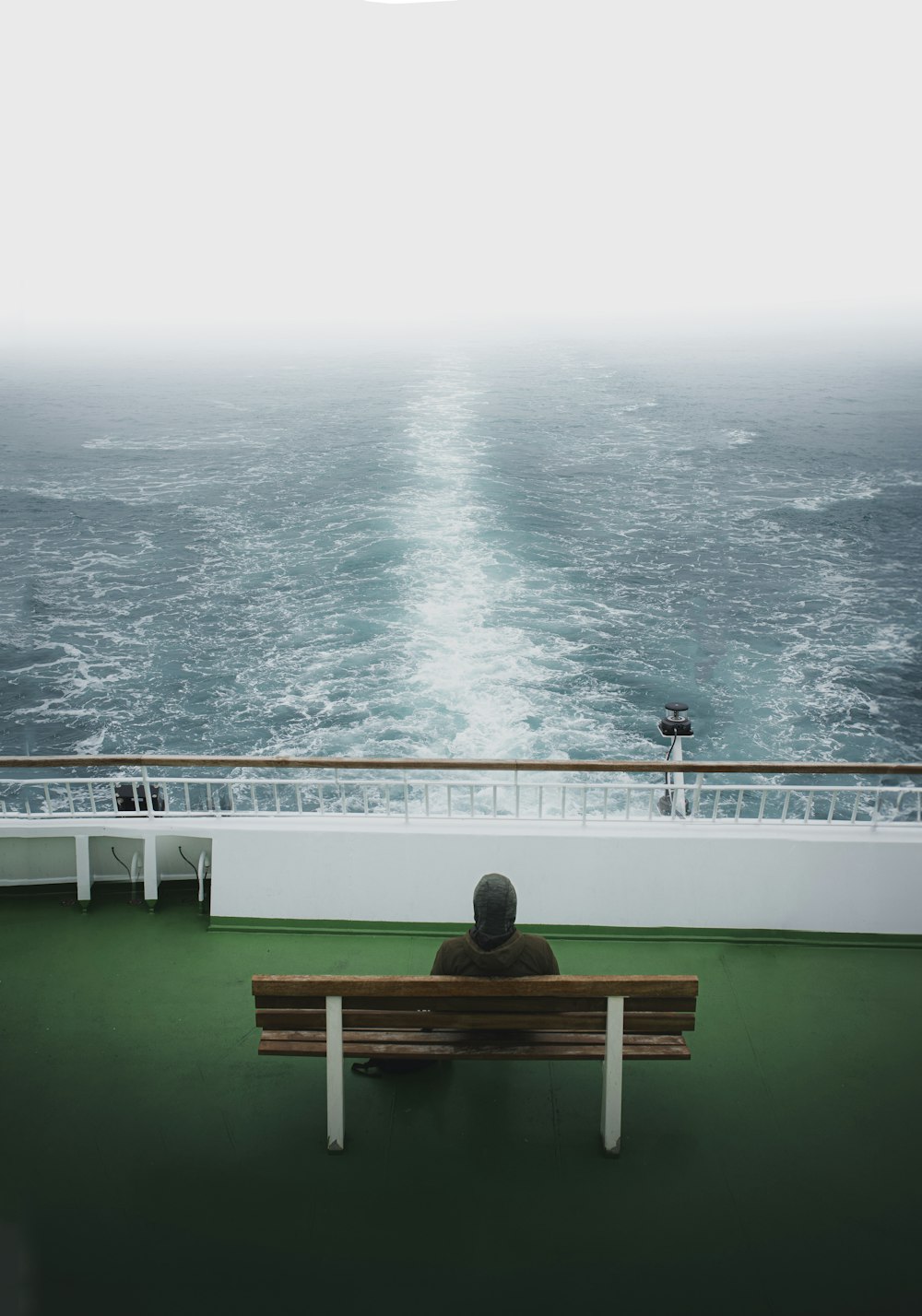 a man sitting on a bench looking out at the ocean