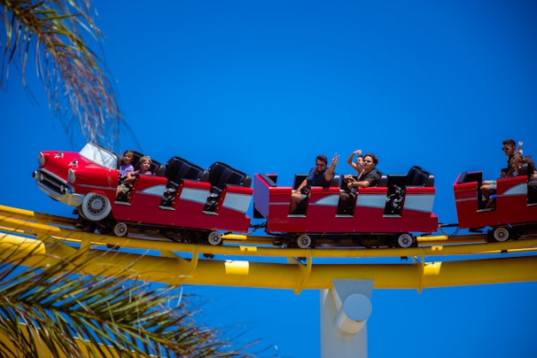 A happy family enjoying riding colorful wooden soapbox cars on a sunny day.
