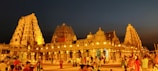 Evening view of the temple lit up with traditional oil lamps during a festival.