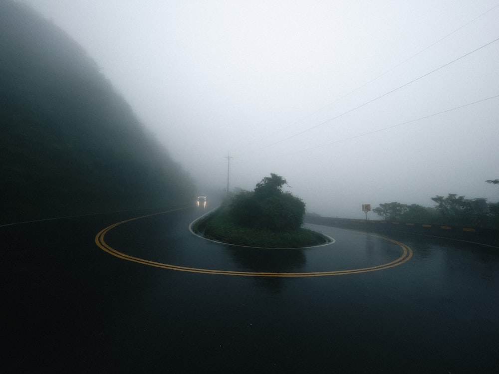 a foggy road with a curve in the middle