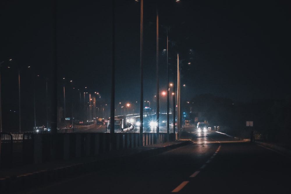 uma rua da cidade à noite com luzes de rua