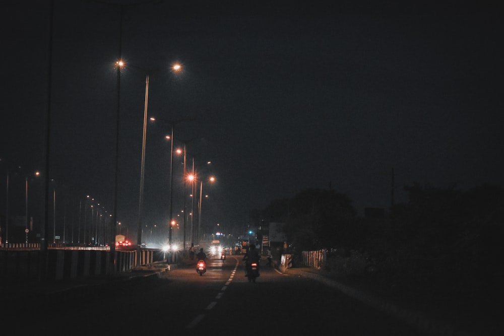 uma pessoa andando de moto por uma rua à noite