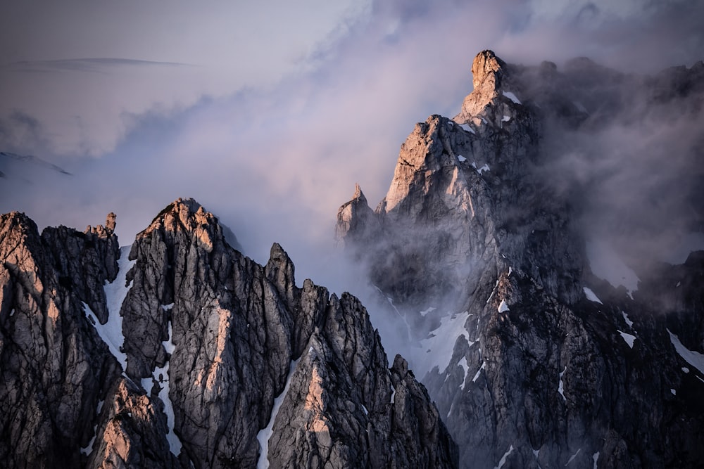 a group of mountains covered in snow and clouds