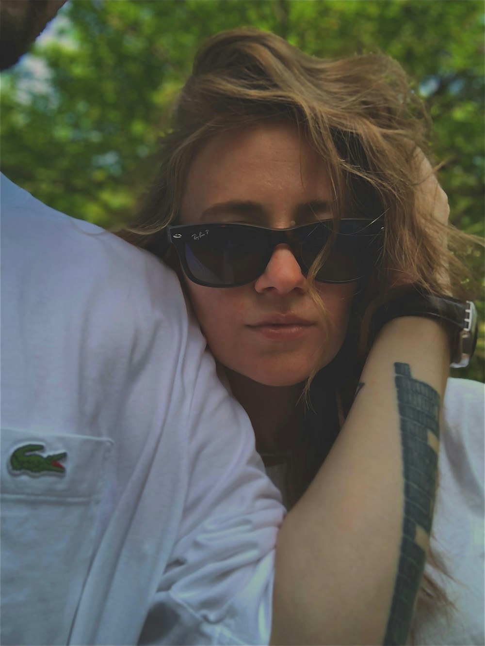 a woman wearing sunglasses and a white shirt