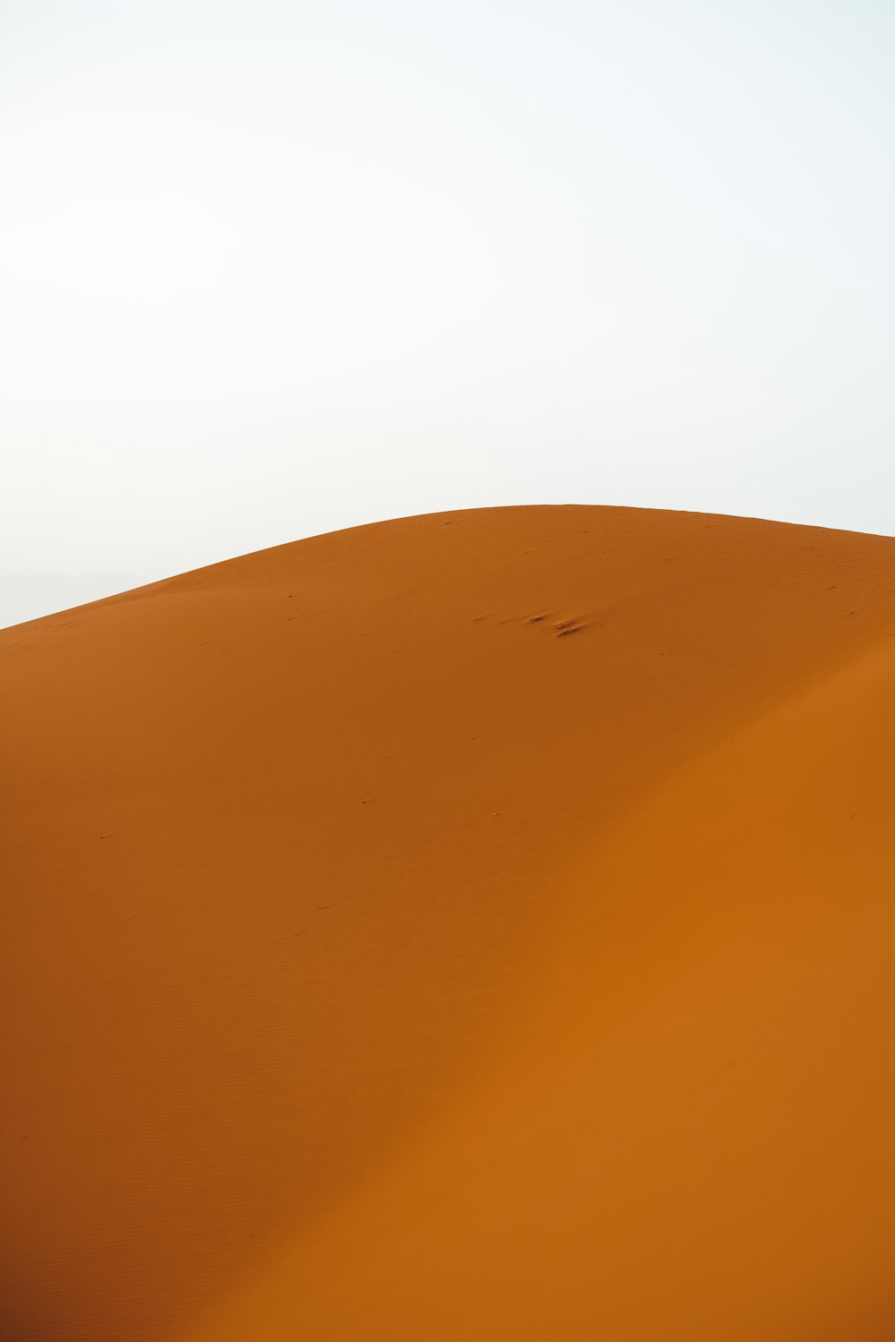 a person walking across a desert with a sky background