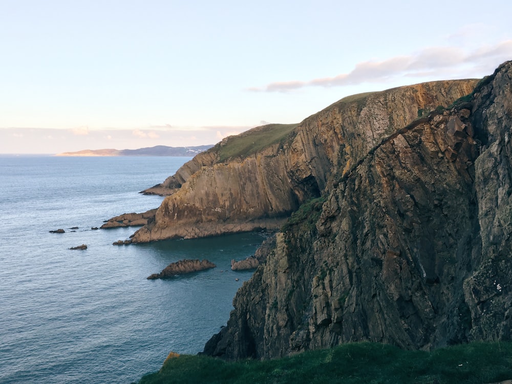 a rocky cliff overlooks a body of water