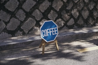 a blue and white sign sitting on the side of a road