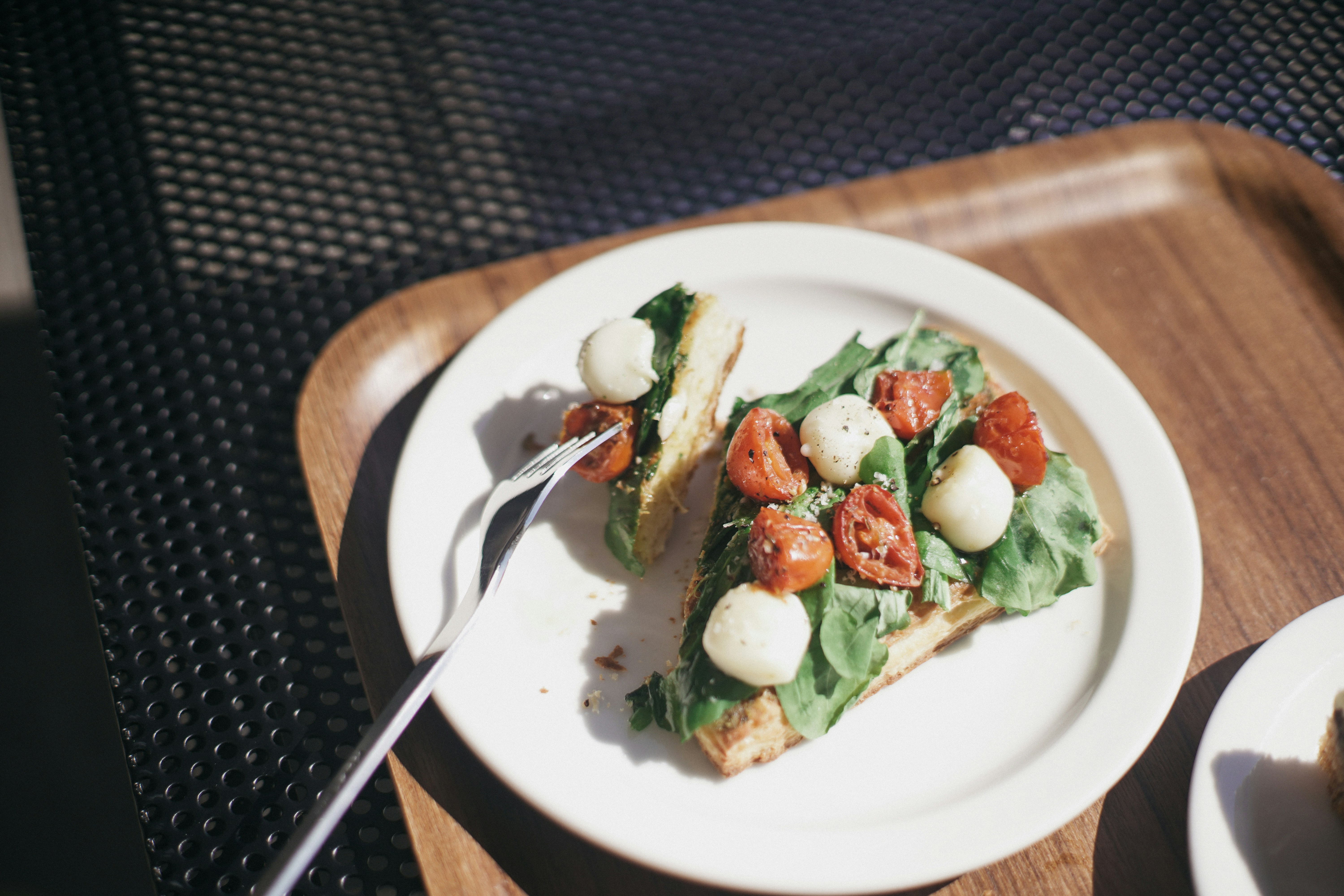 ein weißer Teller mit einem Stück Pizza