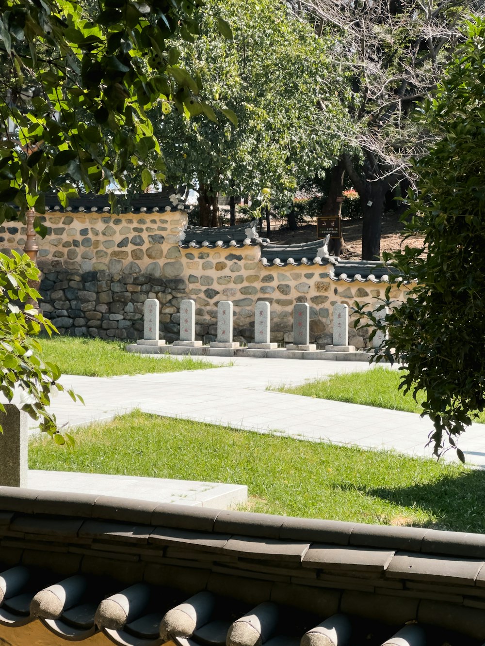 a view of a stone wall and a grassy area