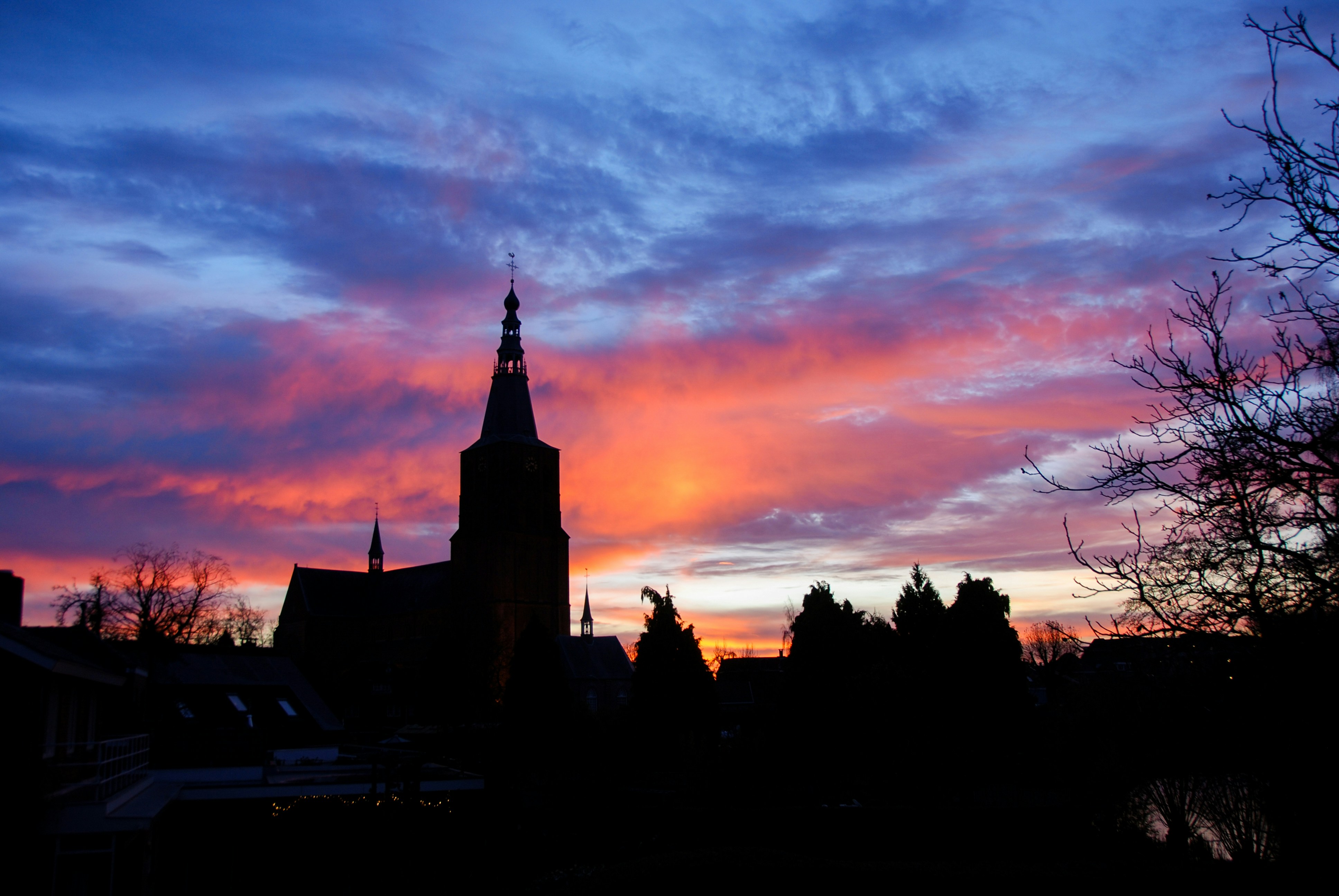 a church steeple with a sunset in the background