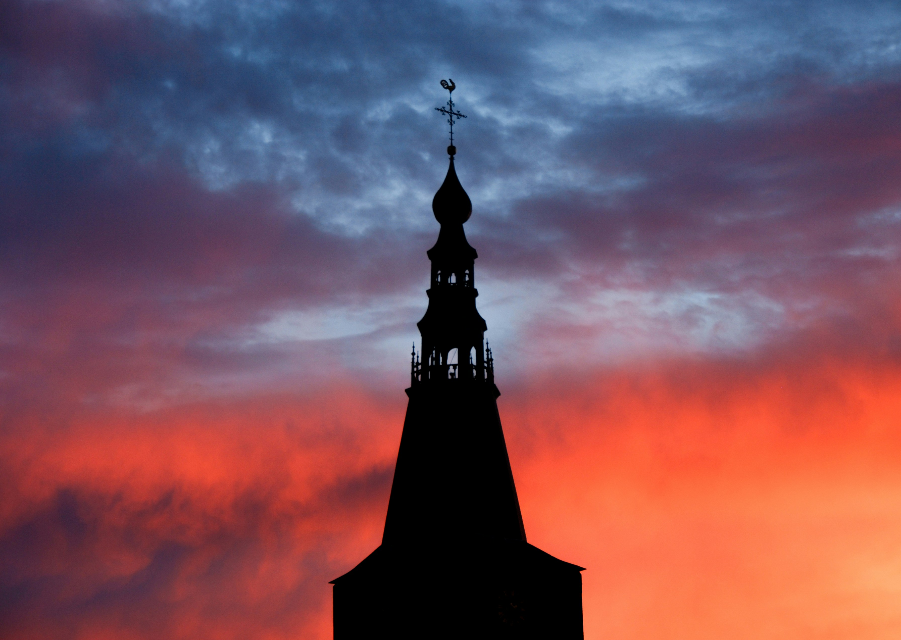 a tall tower with a cross on top of it