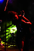 A dynamic shot of a young African musician passionately playing an electric guitar on stage under colorful lights.