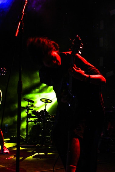 Christopher Robin Cox intensely playing trombone on stage in Budapest with dynamic stage lighting.