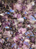 Amethyst crystals sparkling under natural light inside a mineral processing facility.