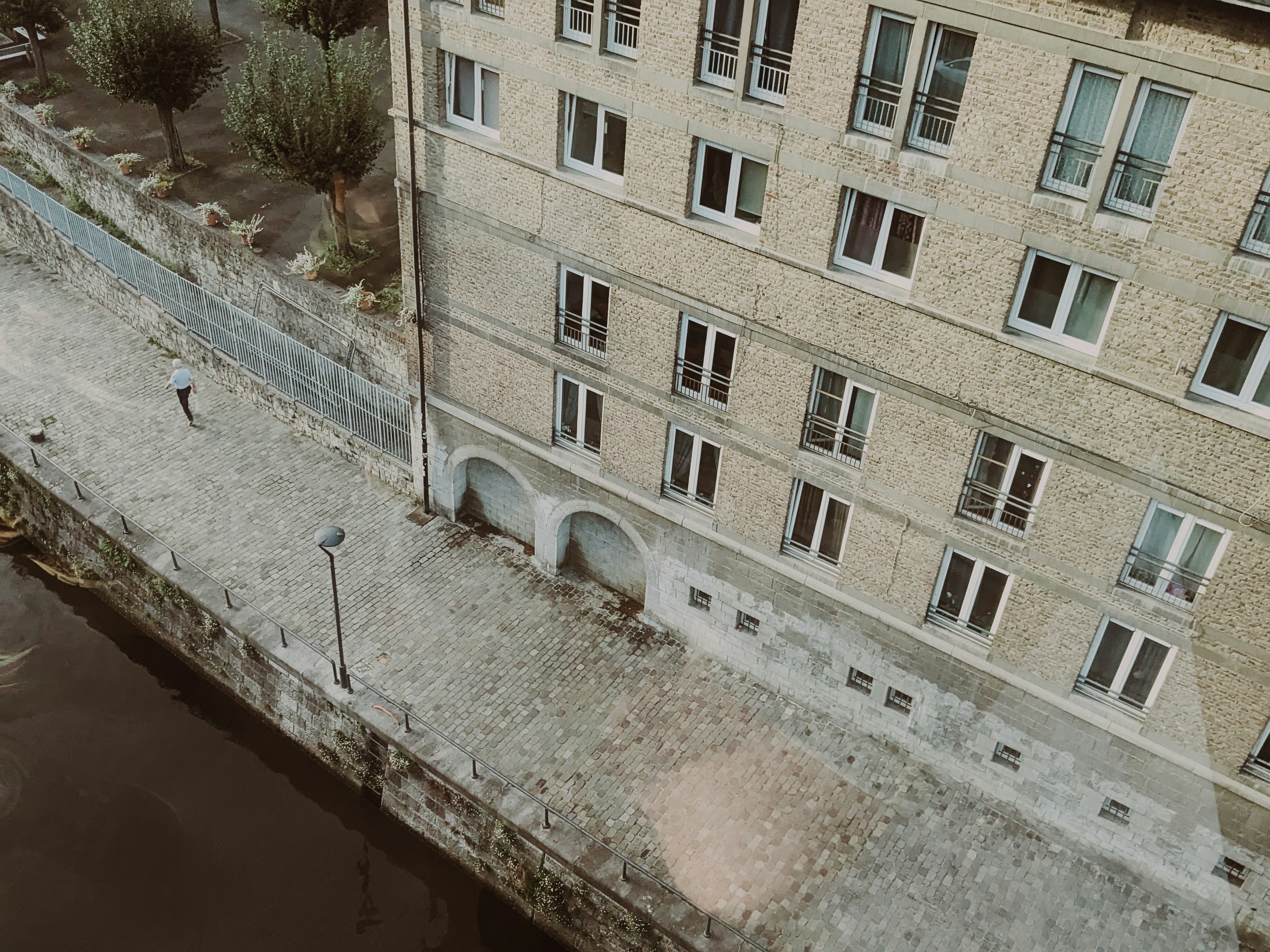 an aerial view of a building next to a body of water