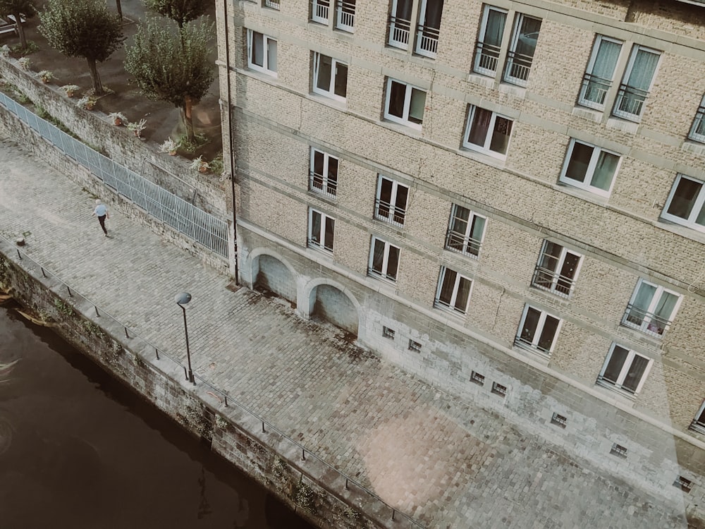 an aerial view of a building next to a body of water