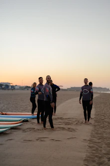 a group of people standing on top of a sandy beach