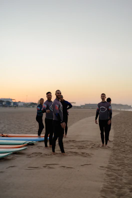 a group of people standing on top of a sandy beach