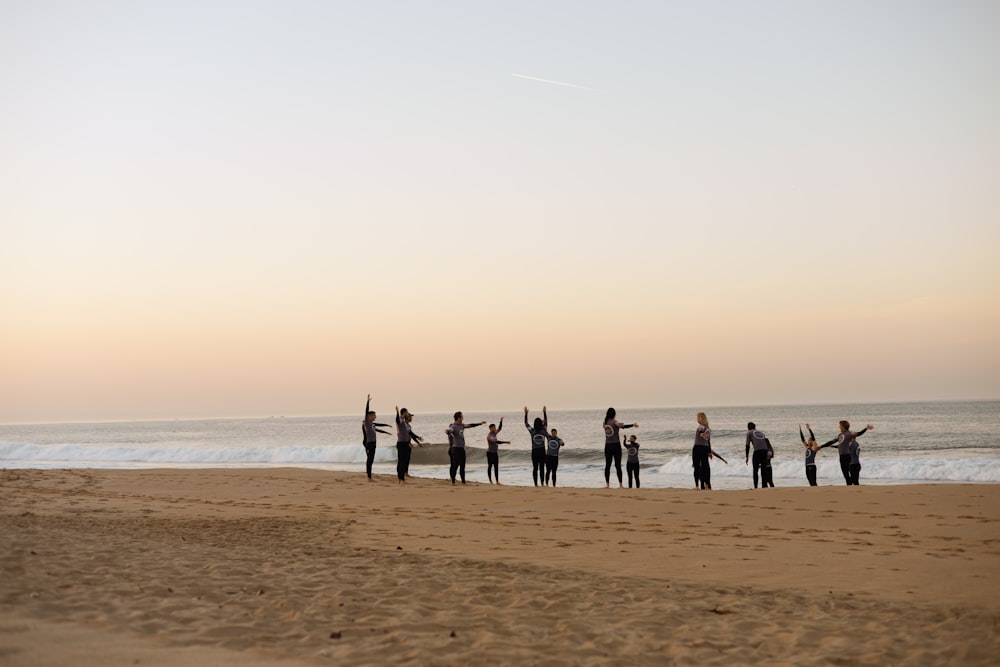 a group of people standing on top of a sandy beach