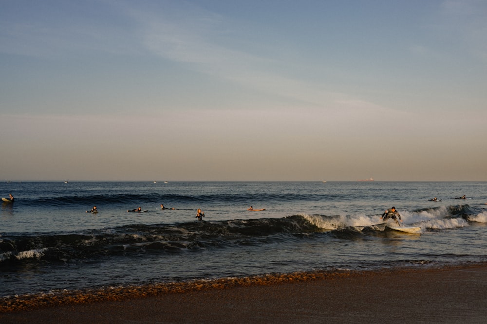 a group of people riding surfboards on top of a wave