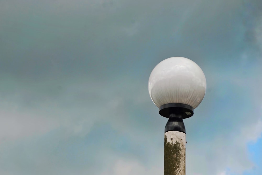 a street light with a cloudy sky in the background