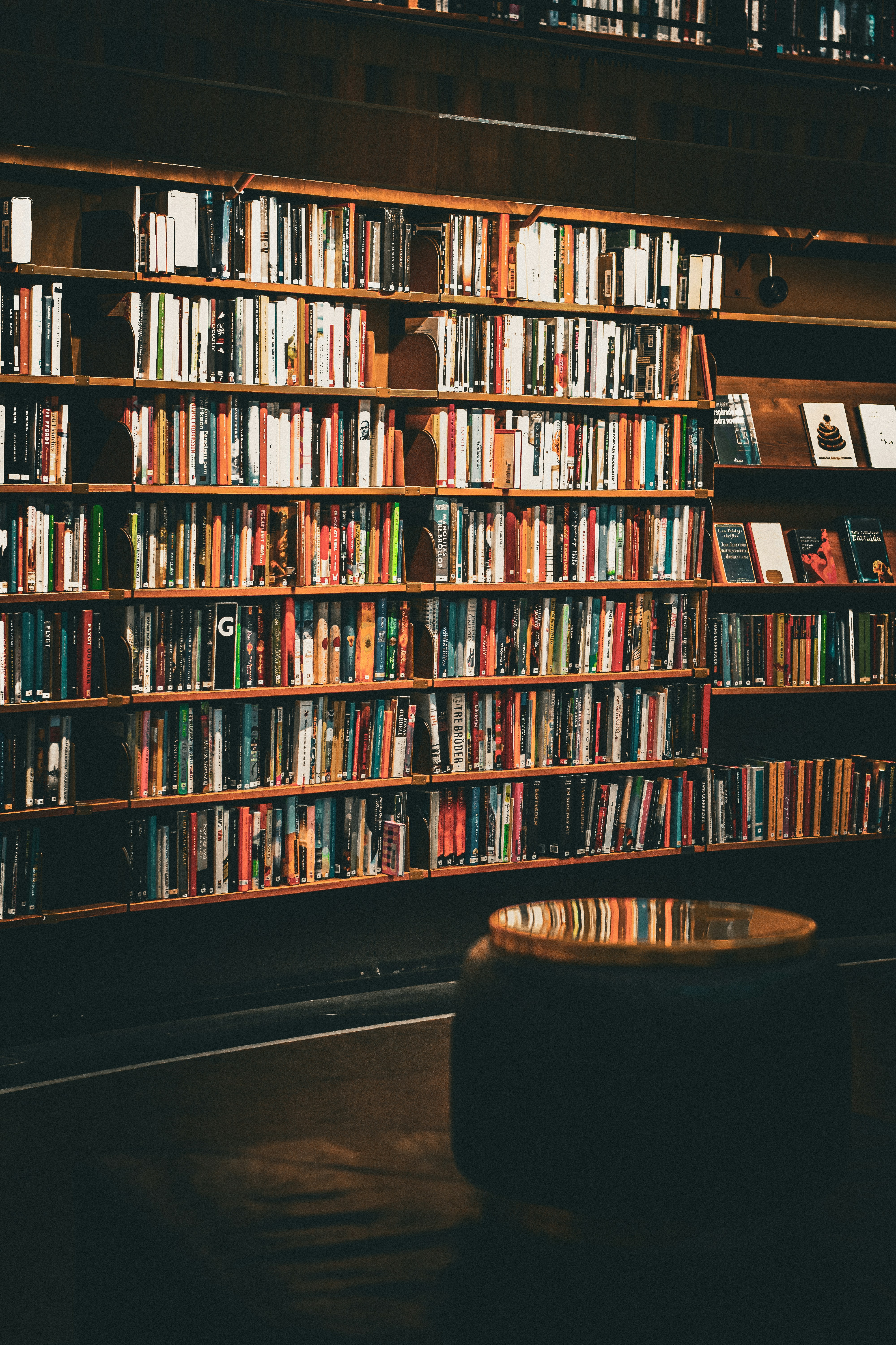 a bookshelf filled with lots of books in a library