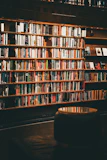 Image of a modular bookshelf with warm wood tones, filled with books and decorative items
