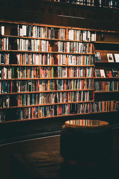 A cozy wooden desk displaying polished wooden book ends holding colorful books upright.